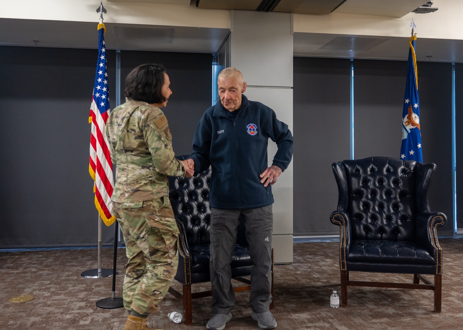 Brig. Gen. Jeannine Ryder, 59th Medical Wing commander, coins Chief Master Sergeant of the Air Force #5 (ret.) Robert Gaylor at Wilford Hall Ambulatory Surgical Center, Joint Base San Antonio-Lackland, Texas, Aug. 2, 2023. In 1957, Gaylor had the opportunity to be a Military Training Instructor and after working as an MTI for male flights, was selected as the senior training noncommissioned officer for the 4734th Women in the Air Force basic training squadron. (U.S. Air Force photo by Senior Airman Melody Bordeaux)