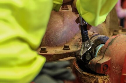 A civilian assigned to Joint Task Force-Red Hill (JTF-RH) secures a bolt on water pump during water-based fire suppressant system testing at the Red Hill Bulk Fuel Storage Facility (RHBFSF) on Joint Base Pearl Harbor-Hickam, Honolulu, Hawaii, Aug. 2, 2023.