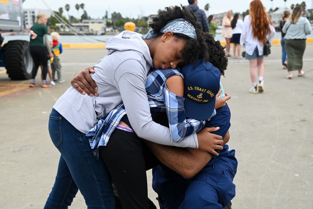 A Coast Guard Cutter Bertholf (WMSL 750) crew member hugs his children after the cutter and crew returned to homeport in Alameda, Calif., Aug. 3, 2023. The Bertholf and crew deployed for 120-days for a Bering Sea patrol in support of United States national security, U.S. fishing fleet safety and prosperity, and the protection of U.S. living marine resources. (U.S. Coast Guard photo by Senior Chief Petty Officer Charly Tautfest)