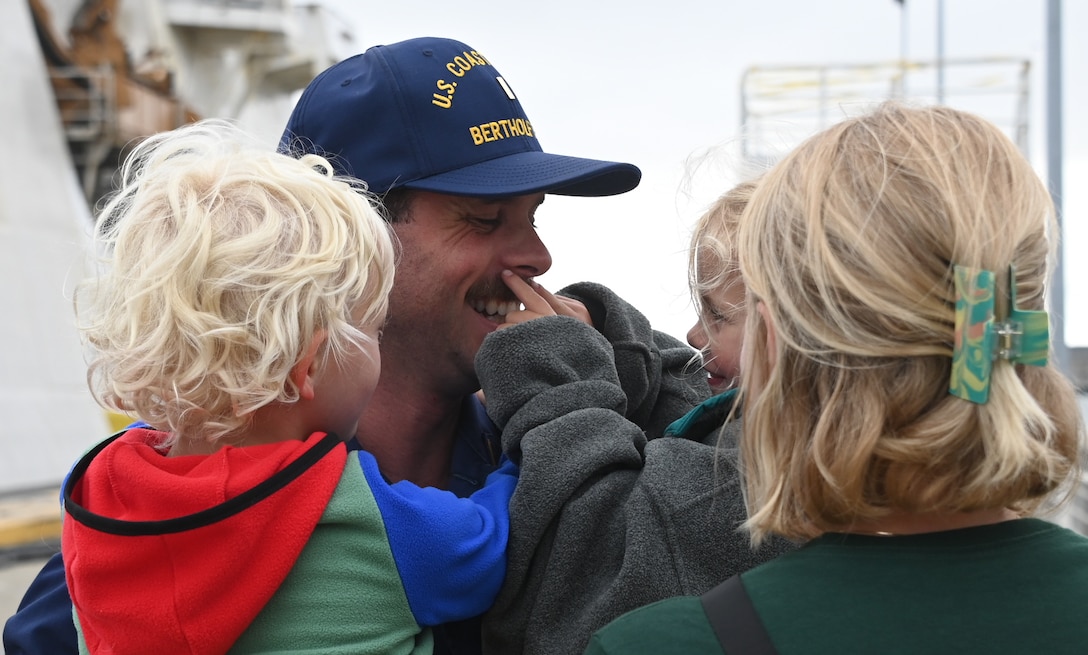 A Coast Guard Cutter Bertholf (WMSL 750) crew member hugs his children after the cutter and crew returned to homeport in Alameda, Calif., Aug. 3, 2023. The Bertholf and crew deployed for 120-days for a Bering Sea patrol in support of United States national security, U.S. fishing fleet safety and prosperity, and the protection of U.S. living marine resources. (U.S. Coast Guard photo by Senior Chief Petty Officer Charly Tautfest)