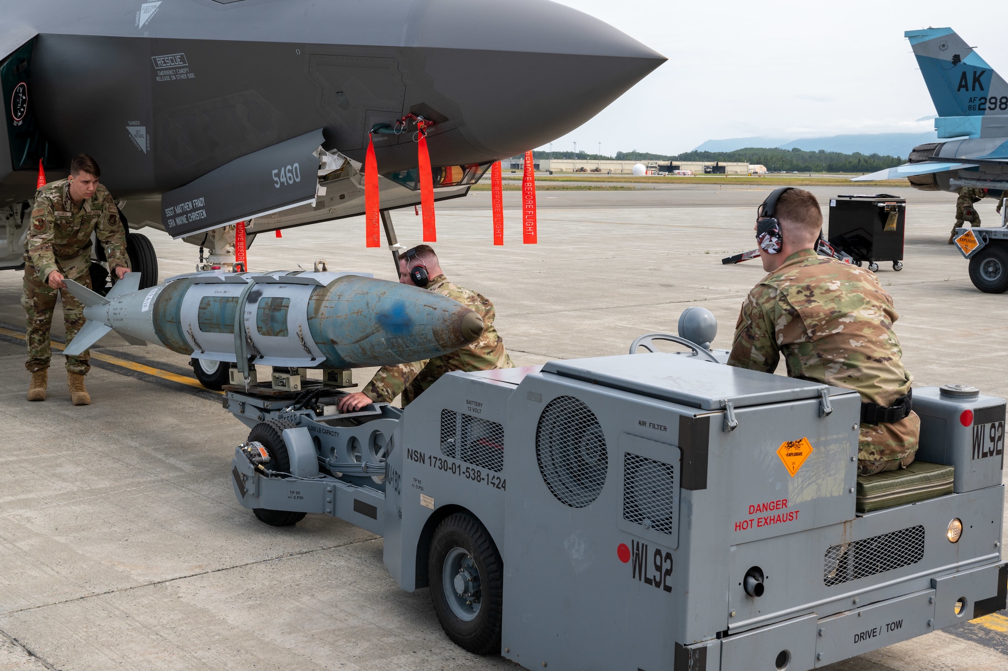 Weapons load crew assigned to the 356th Fighter Generation Squadron, Eielson AFB, load a training bomb during a load competition at JBER, July 28, 2023