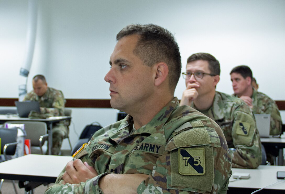 Capt. Marc Easton, an assistant research engineer, listens intently during a brainstorming session on July 19, on how to sift through large data available in the public domain. The 75th Innovation Command hosted the Code-A-Thon, an eight-day event on Joint Reserve Base Ellington Field, Texas, that began July 17, 2023. The event was to build planning for technology-based capabilities for the Army by leveraging the Army Reserve Soldiers’ civilian expertise, such as generative artificial intelligence and data science. (U.S. Army photo by Maj. Charles An)