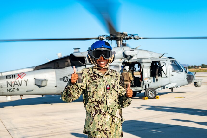 Logistics Specialist 1st Class Denitra Richardson, assigned to Naval Support Activity Souda Bay, assists with an orientation ride in an MH-60S Sea Hawk, assigned to Helicopter Sea Combat Squadron 9, in Souda Bay, Greece, on July 19, 2023.