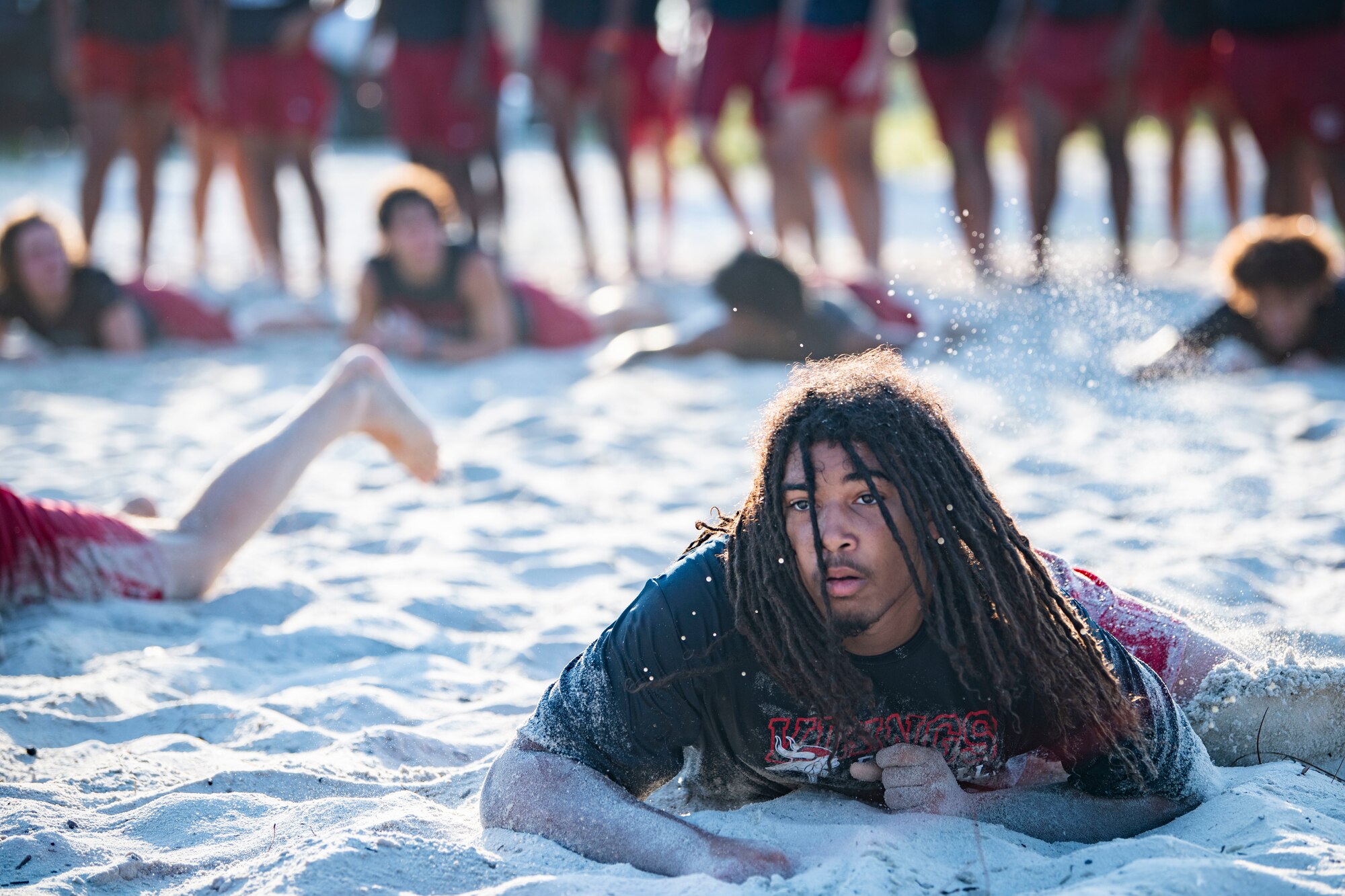 The Fort Walton Beach High School Vikings football team crawls through the sand during Air Commando Youth Athletic Camp at Hurlburt Field, Florida, July 26, 2023.