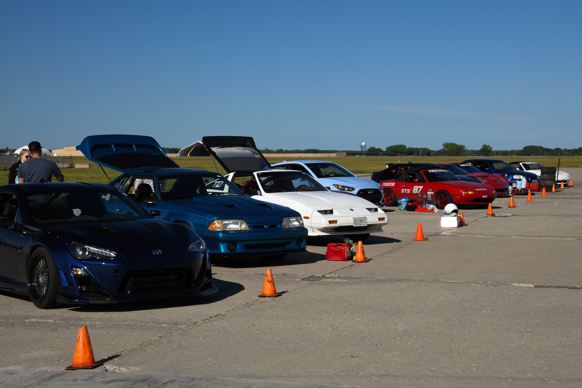 Several cars line a concrete pad.