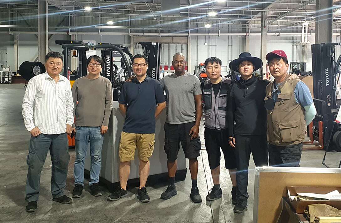 Coworkers pose in a warehouse.