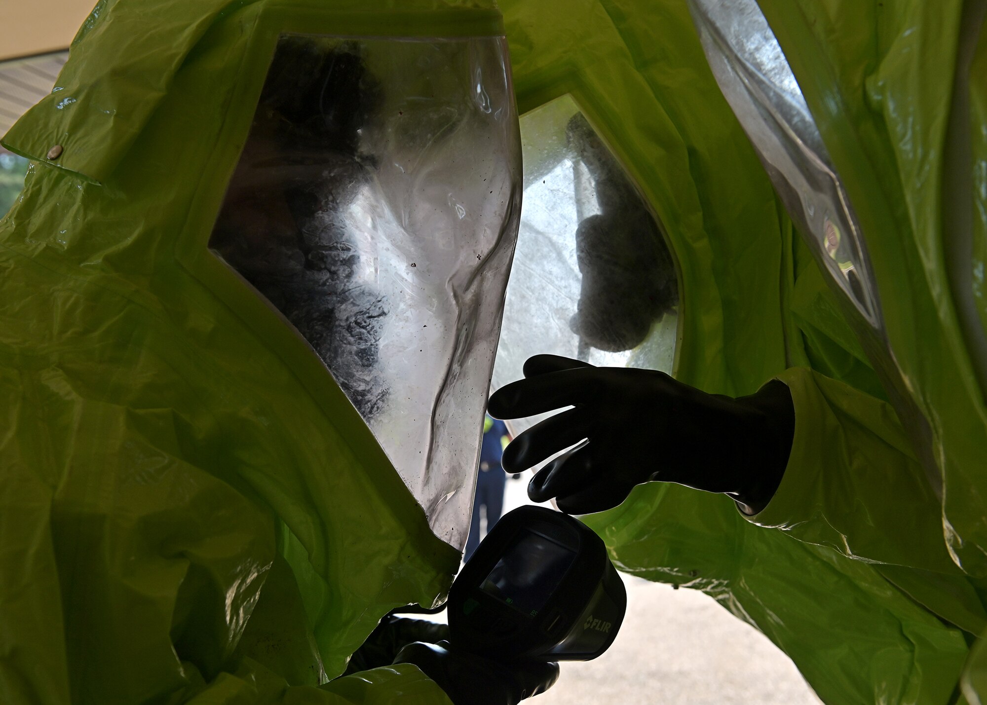Firefighters communicate while assessing a simulated hazardous materials spill.