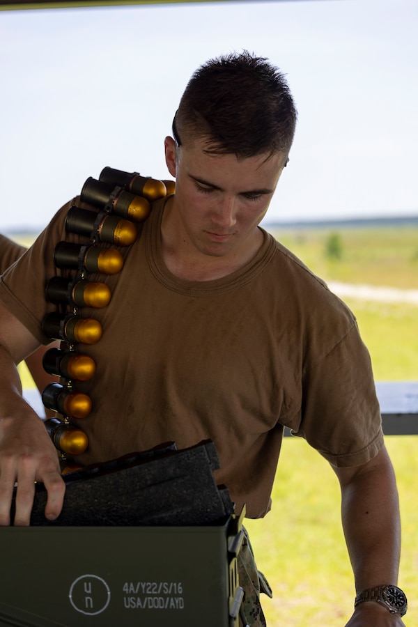 Midshipman 1st Class Charles Longacre, a Prescott, Arizona, native and senior at the U.S. Naval Academy, prepares  Mark 19 40 mm grenade machine gun ammunition prior to a live-fire range with Marine Raiders from Marine Forces Special Operations Command on Camp Lejeune, North Carolina, July 26, 2023. While training with MARSOC, the midshipmen were able to experience the variety of tools and weapons employed by critical skills operators and special operations officers. (U.S. Marine Corps photo by Cpl. Henry Rodriguez)