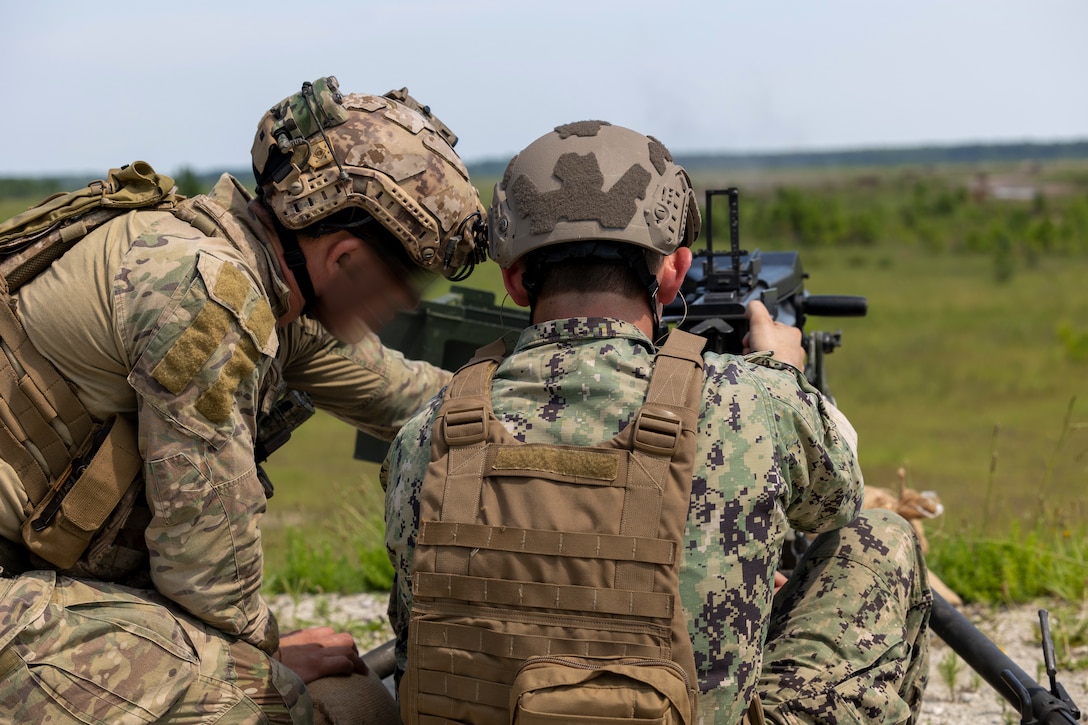 Midshipman 1st Class Samuel Murray, a Bay Village, Ohio, native and senior at the U.S. Naval Academy, fires a Mark 19 40 mm grenade machine gun under the coaching of a Marine Raider from Marine Forces Special Operations Command on Camp Lejeune, North Carolina, July 26, 2023. While training with MARSOC, the midshipmen were able to experience the variety of tools and weapons employed by critical skills operators and special operations officers. (U.S. Marine Corps photo by Cpl. Henry Rodriguez)