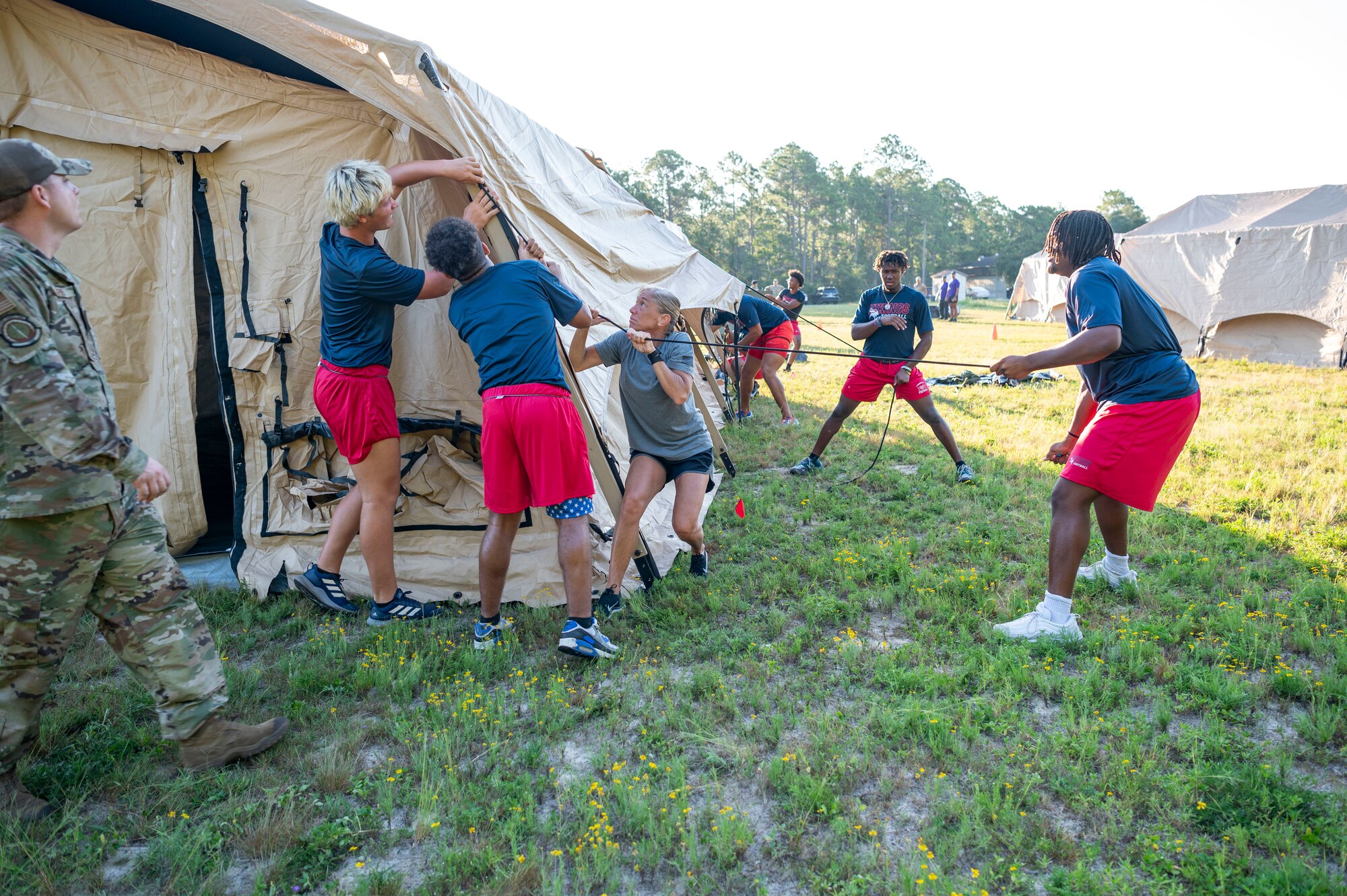 U.S. Air Force Col. Allison Black, 1st Special Operations Wing commander, helps the Fort Walton Beach High School Vikings football team build military tents during Air Commando Youth Athletic Camp at Hurlburt Field, Florida, Aug. 2, 2023.