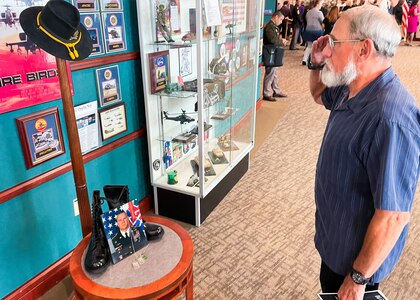 Man salutes a memorial of a Soldier.