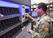 A man in uniform presses buttons on a machine that fills prescriptions.