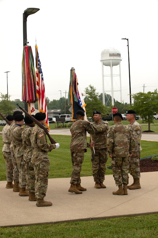 U.S. Army Sgt. Maj. Darvin Williams hands V Corps' outgoing command sergeant major, Command Sgt. Maj. Raymond Harris, the V Corps colors during a change of responsibility ceremony at V Corps Headquarters on Fort Knox, Kentucky, Aug. 4, 2023. V Corps conducted a change of responsibility ceremony for Harris who released responsibility to Command Sgt. Maj. Philip Blaisdell. (U.S. Army photo by Sgt. Gabriella Sullivan)