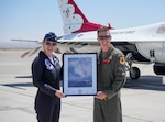 U.S. Air Force Maj. Lauren Schlichting, #4 Thunderbird for the U.S. Air Force Air Demonstration Team, presents Maj. Tyler Clark, 173rd Fighter Wing F-15C instructor pilot, with a signed photo after his flight evaluation July 6, 2023, at Nellis Air Force Base, Nevada. Clark was selected as one of the newest demonstration pilots for the U.S. Air Force Demonstration Squadron in the 2024-2025 season.