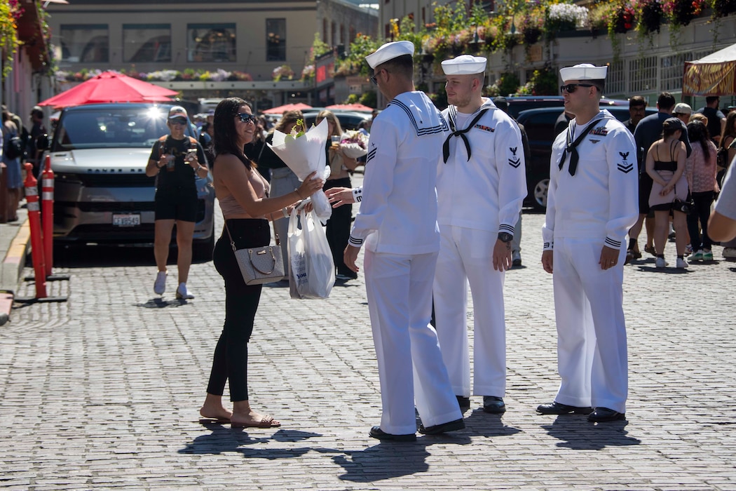 230802-N-YF131-1122 SEATTLE (Aug. 2, 2023) Cryptologic Technician (Collection) Seaman Kaden Boyce, left, from Front Royal, Va., assigned to the Arleigh Burke-class guided missile destroyer USS Barry (DDG 52) gives away flowers at Pike Place Market during Seattle Fleet Week, Aug. 2, 2023. Seattle Fleet Week is a time-honored celebration of the sea services and provides an opportunity for the citizens of Washington to meet Sailors, Marines and Coast Guardsmen, as well as witness firsthand the latest capabilities of today’s U.S. and Canadian maritime services. (U.S. Navy photo by Mass Communication Specialist 2nd Class Madison Cassidy)