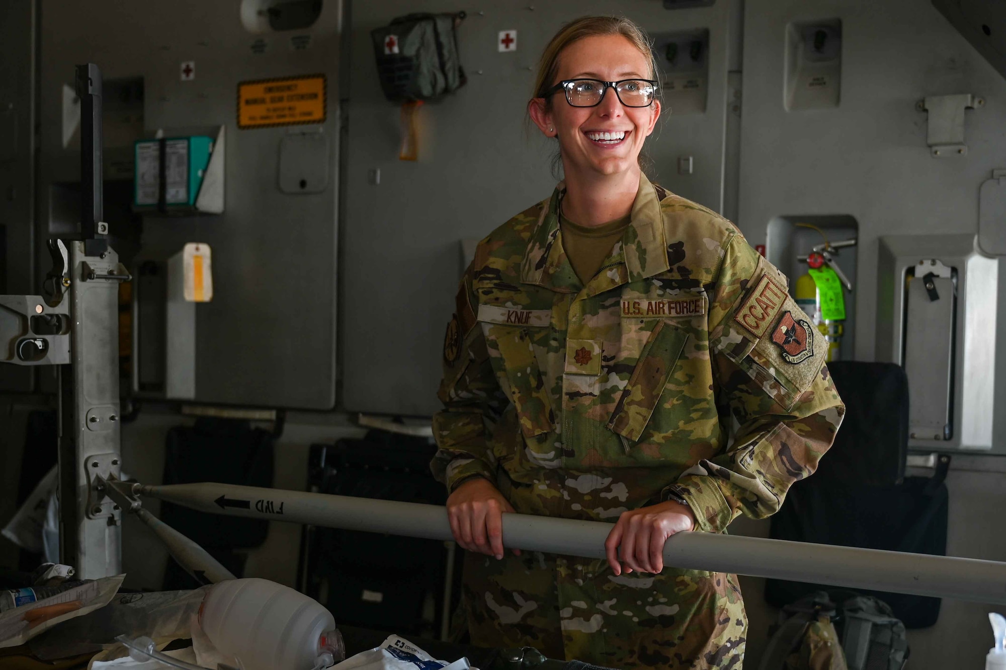 U.S. Air Force Maj. Kayla Knuf, 59th Medical Wing critical care air transport (CCAT) physician, poses for a photo in a C-17 Globemaster III static from Altus Air Force Base, Oklahoma, in Oshkosh, Wisconsin, July 29, 2023. Knuf spoke with AirVenture Air Show attendees and showed them what kind of technology CCAT physicians and technicians use when taking care of patients in air transport. (U.S. Air Force photo by Airman 1st Class Kari Degraffenreed)