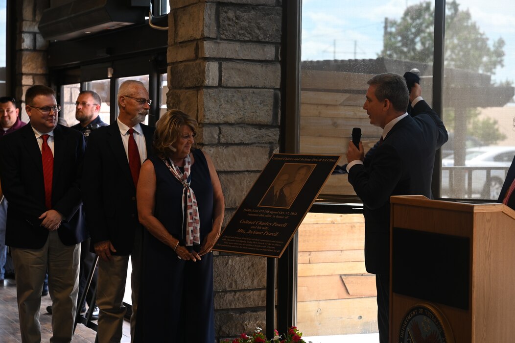 Keith Bass, West Texas Veteran Affairs Health Care System Medical Center director, displays the memorial for Charles and JoAnne Powell with their family during the Veteran Affairs Clinic renaming ceremony, San Angelo, Texas, July 31, 2023. The memorial serves as a reminder of the dedication that both Charles and JoAnne Powell had to continue the improvement of their local community. (U.S. Air Force photo by Airman 1st Class Madison Collier)
