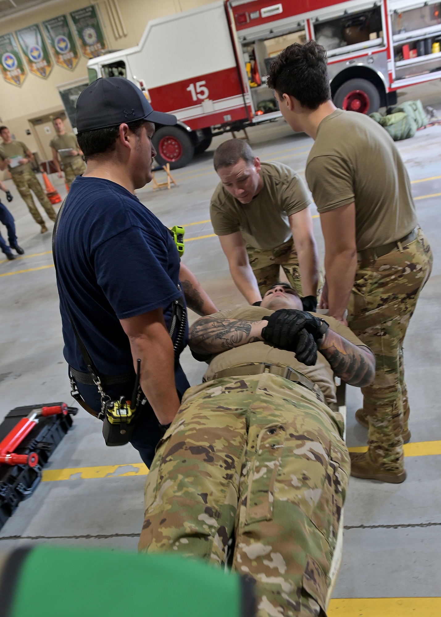 A simulated injured firefighter is carried away from a simulated hazardous materials spill.