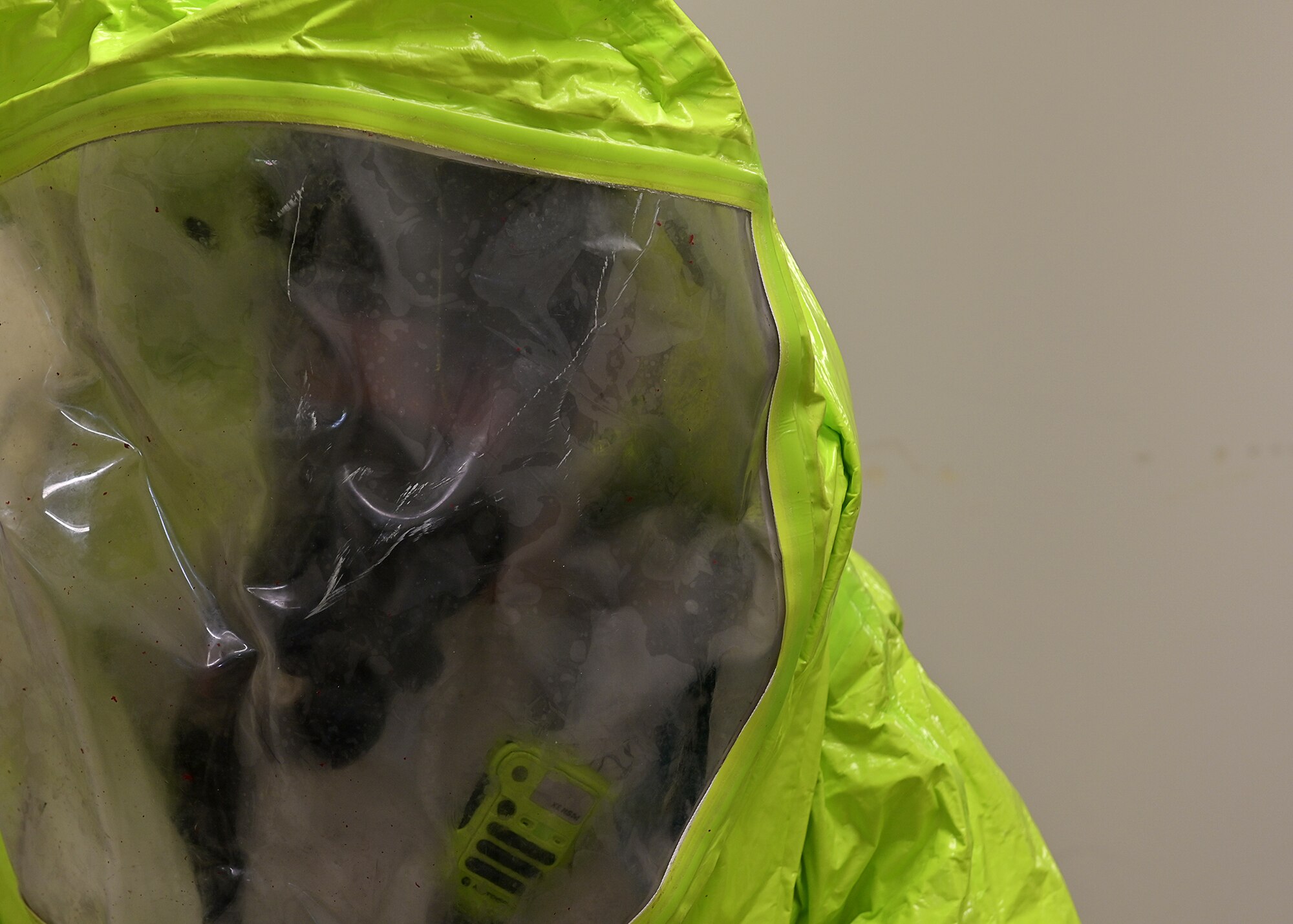 A firefighter waits in a hallway to enter a simulated hazardous materials spill area.