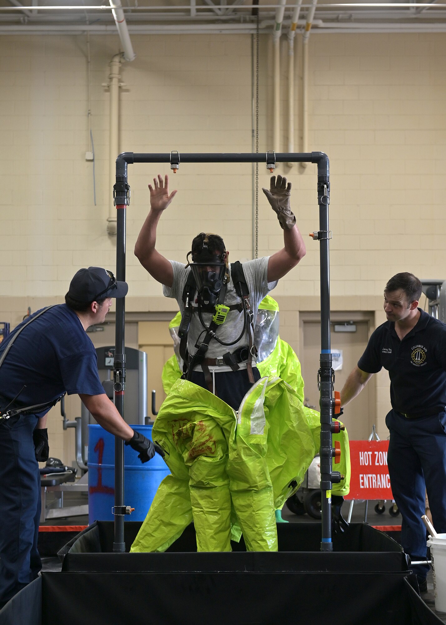 Firefighters decontaminate personnel exposed to simulated hazardous materials.