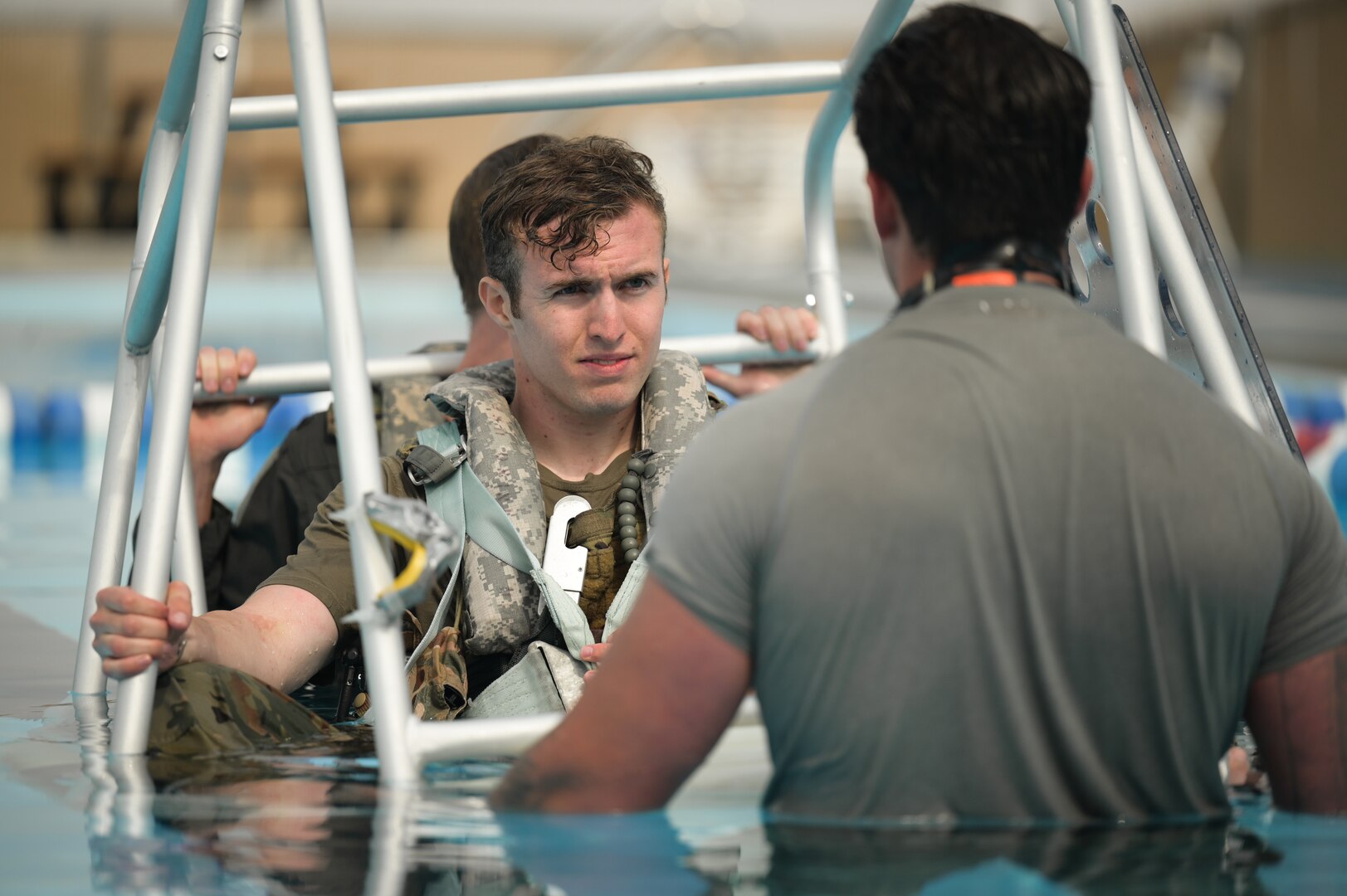 A man sits in a silver cage in water, listening to instructions before getting plunged.