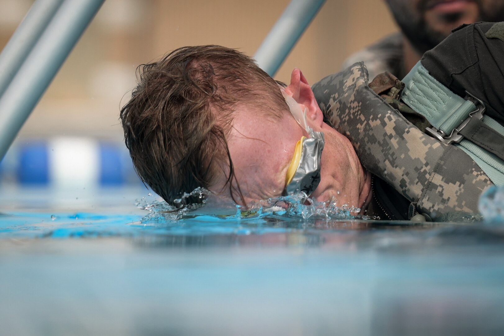 A man's face is plunged into water.