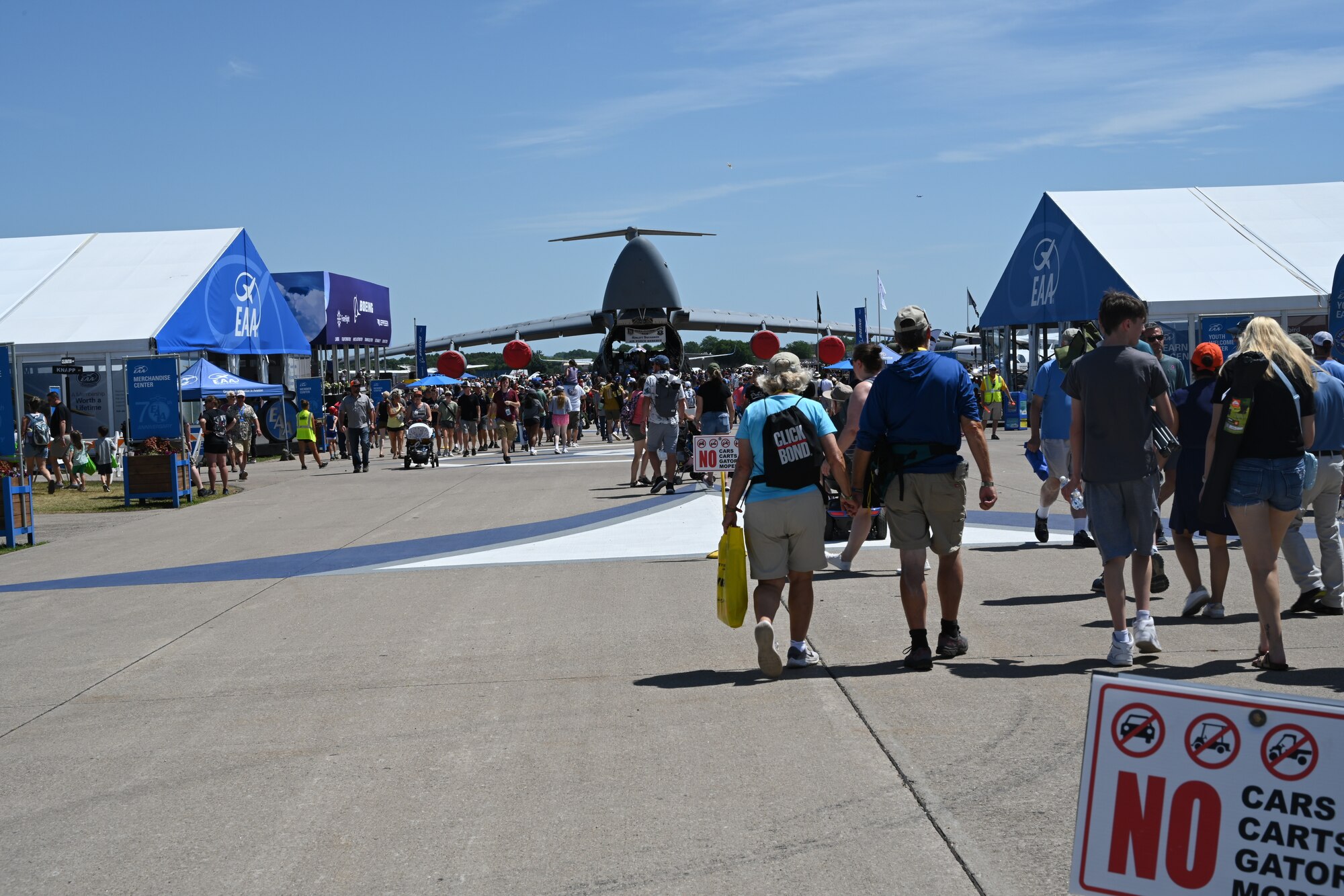 Attendees flock toward a C-5 Galaxy at the Experimental Aviation Association AirVenture Air Show in Oshkosh, Wisconsin, July 28, 2023. Military working dogs, recruiters and static displays were located in one area to invite attendees to get to know about service members, their jobs, and their aircraft. (U.S. Air Force photo by Airman 1st Class Miyah Gray)