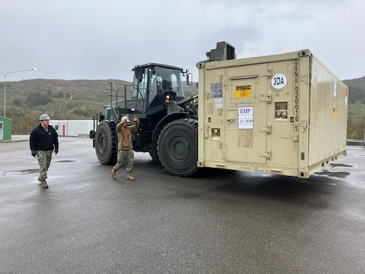 CM1 Curtis Cox conducts training while EO2 Tyler Campbell operates a 25K Rough Terrain Container Handler and EO2 Gage Bochette ground guides.