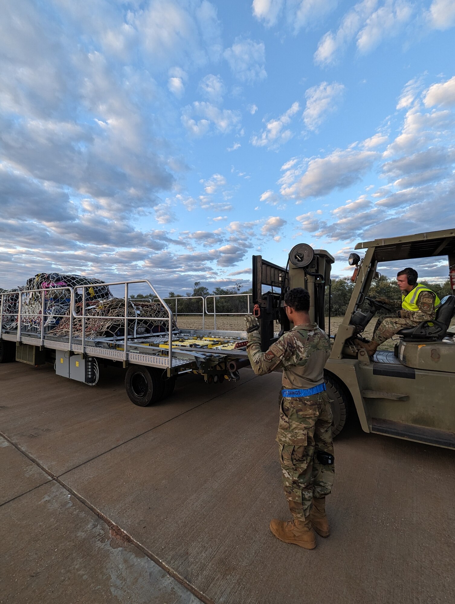 U.S. Air Force Staff Sgt. Taylor Pate, aerial port supervisor, and Airman Curtis Norris, aerial port apprentice, both assigned to the 36th Contingency Response Squadron, 36th Wing, Andersen Air Force Base, Guam, utilize Royal Australian Air Force (RAAF) equipment to transport cargo as RAAF No. 3 Squadron equipment and personnel arrive for Talisman Sabre 23 at RAAF Base Curtin, Northern Territory, Australia, July 20, 2023. Talisman Sabre is a bilateral exercise that helps build and maintain trust and interoperability among key allies through shared experiences and tough, realistic training.