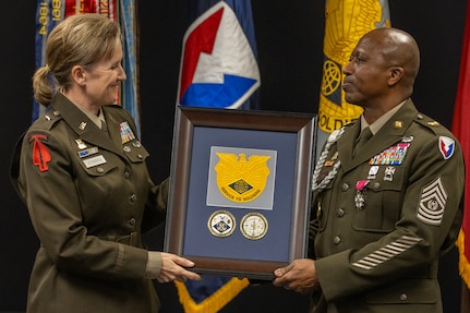 Brig. Gen. Paige M. Jennings, U.S. Army Financial Managment Command commanding general, presents USAFMCOM's distinguished unit insignia and coins to Command Sgt. Maj. Kenneth F. Law, USAFMCOM senior enlisted advisor, during his retirement ceremony at the Maj. Gen. Emmett J. Bean Federal Center in Indianapolis March 31, 2023. Law retired from active duty after more than 30 years of service. (U.S. Army photo by Mark R. W. Orders-Woempner)