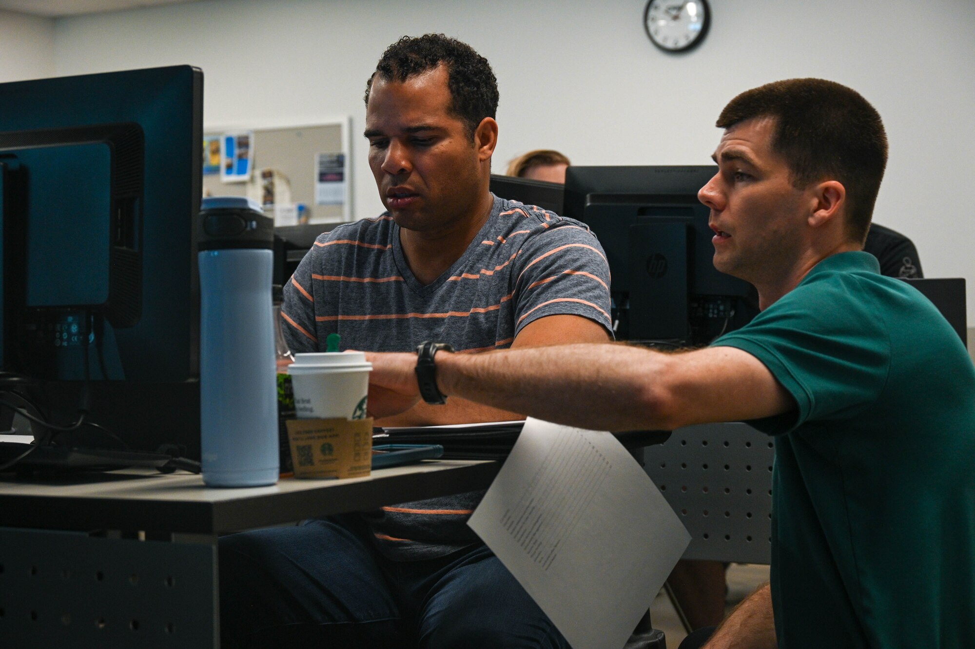 A teacher is helping a student at their computer.