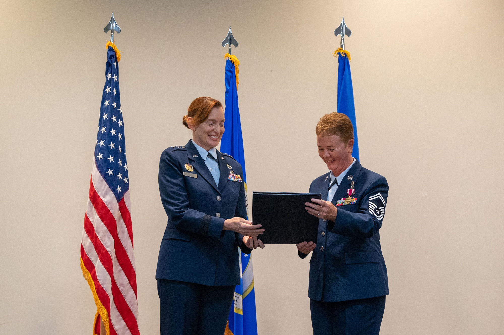 Gunter and Baldelli hold a certificate between them and appear to be reading it