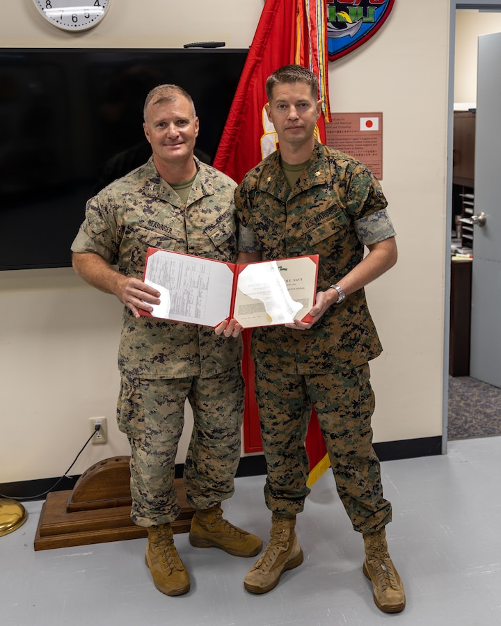 U.S. Marine Maj. Evlin Finnicum, an exercise planner, L5, is awarded the Navy Achievement Medal by Col. Clay Readinger, chief of staff, 3rd Marine Expeditionary Brigade, III Marine Expeditionary Force, and Task Force 76/3, during an award ceremony on Camp Courtney, Okinawa, Japan, Jun. 12, 2023. Maj Finnicum, a native of HOMETOWN, STATE, (U.S. Marine Corps photo by Staff Sgt. Andrew Ochoa)