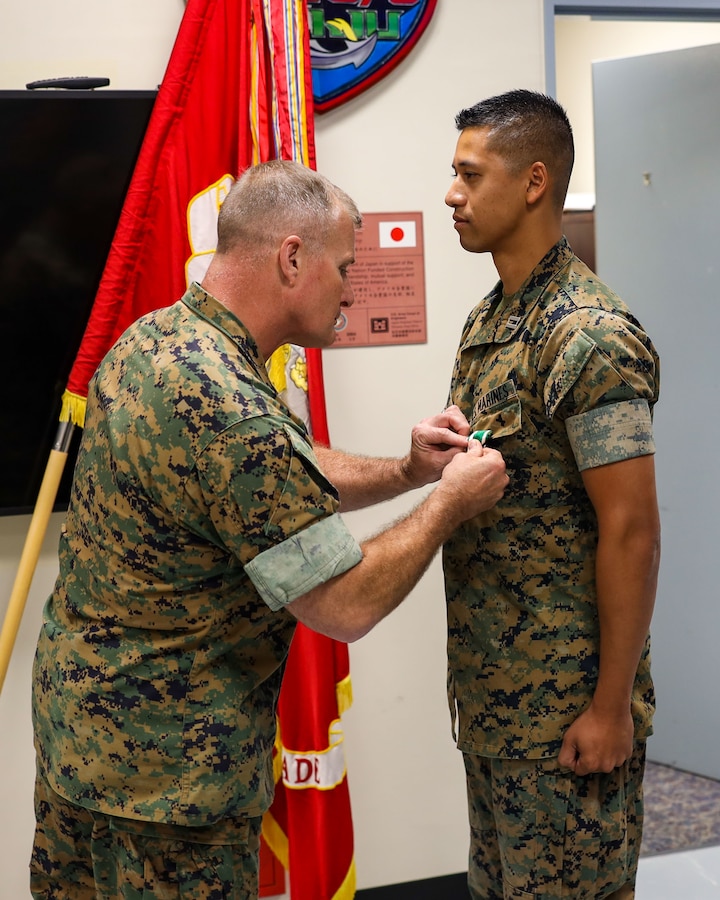 U.S. Marine Col. Clay Readinger, chief of staff, 3rd Marine Expeditionary Brigade, III Marine Expeditionary Force and Task Force 76/3, presents the Navy Achievement Medal to Capt. Naro Neang, anti-terrorism and force protection officer, during an awards presentation on Camp Courtney, Okinawa, Japan, Jun. 22, 2023. (U.S. Marine Corps photo by Staff Sgt. Andrew Ochoa)