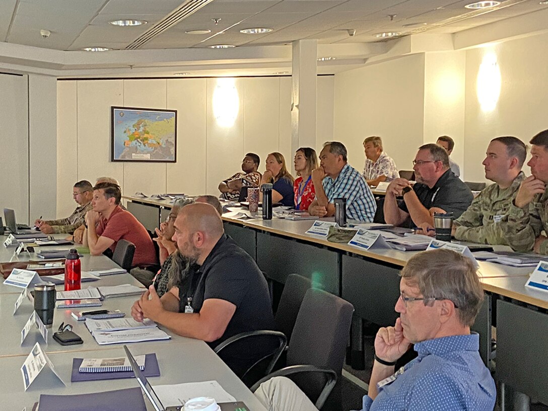 People listening to a person give a presentation.