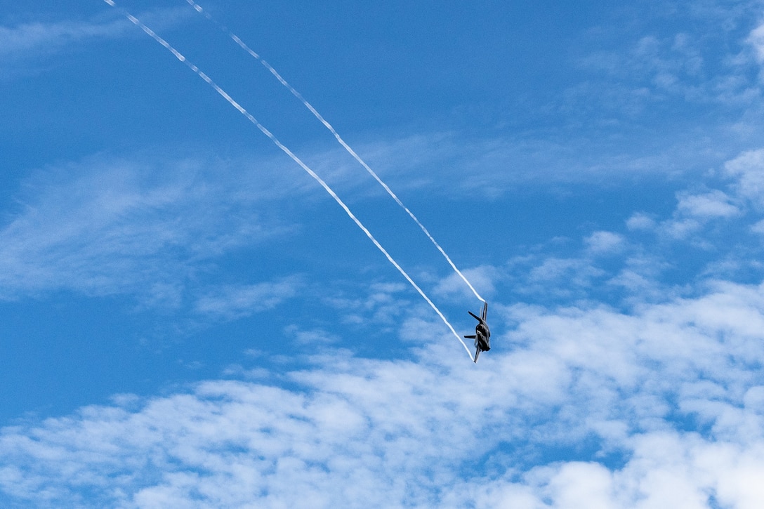 A fighter jet flies across the sky.