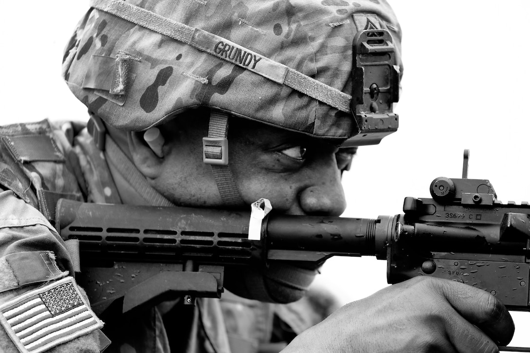 A soldier looks through his gun sight.