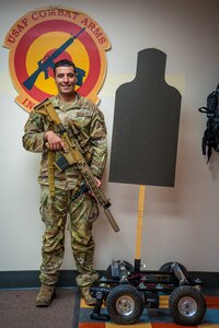 Man poses with rifle.