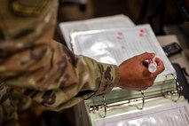 U.S. Air Force Senior Airman Bryan Nunez, 628th Air Base Wing Command Post senior emergency actions controller, runs through a checklist during weather notifications at Joint Base Charleston, South Carolina, July 27, 2023.