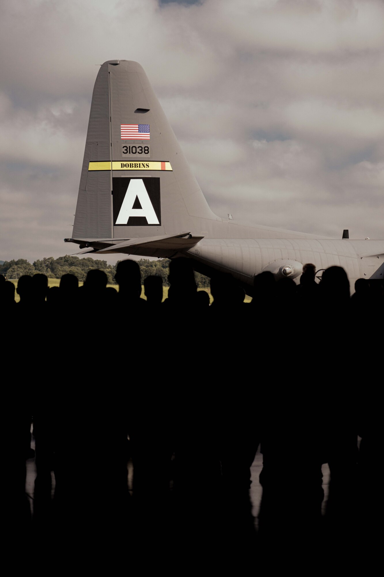 Members of the 94th Airlift Wing stand in formation in front of a C-130 Hercules aircraft.