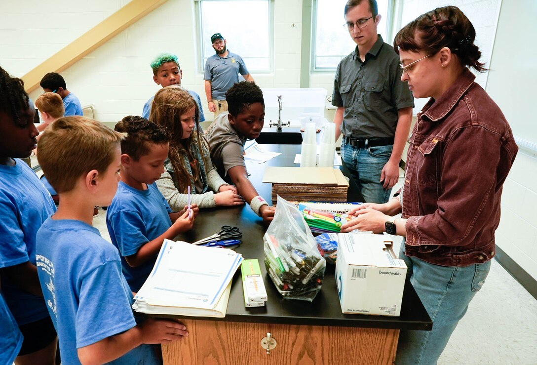 IMAGE: Kelly Morgan, a scientist in the Strategic and Computing Systems Department at Naval Surface Warfare Center Dahlgren Division, and Nicholas Giampetro, a student trainee in the Weapons Control and Integration Department, allow children at the Spotsylvania County Sheriff’s Office STEM Camp to shop for materials to build a boat July 31 at the Germanna Community College Fredericksburg Area Campus.