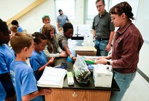IMAGE: Kelly Morgan, a scientist in the Strategic and Computing Systems Department at Naval Surface Warfare Center Dahlgren Division, and Nicholas Giampetro, a student trainee in the Weapons Control and Integration Department, allow children at the Spotsylvania County Sheriff’s Office STEM Camp to shop for materials to build a boat July 31 at the Germanna Community College Fredericksburg Area Campus.