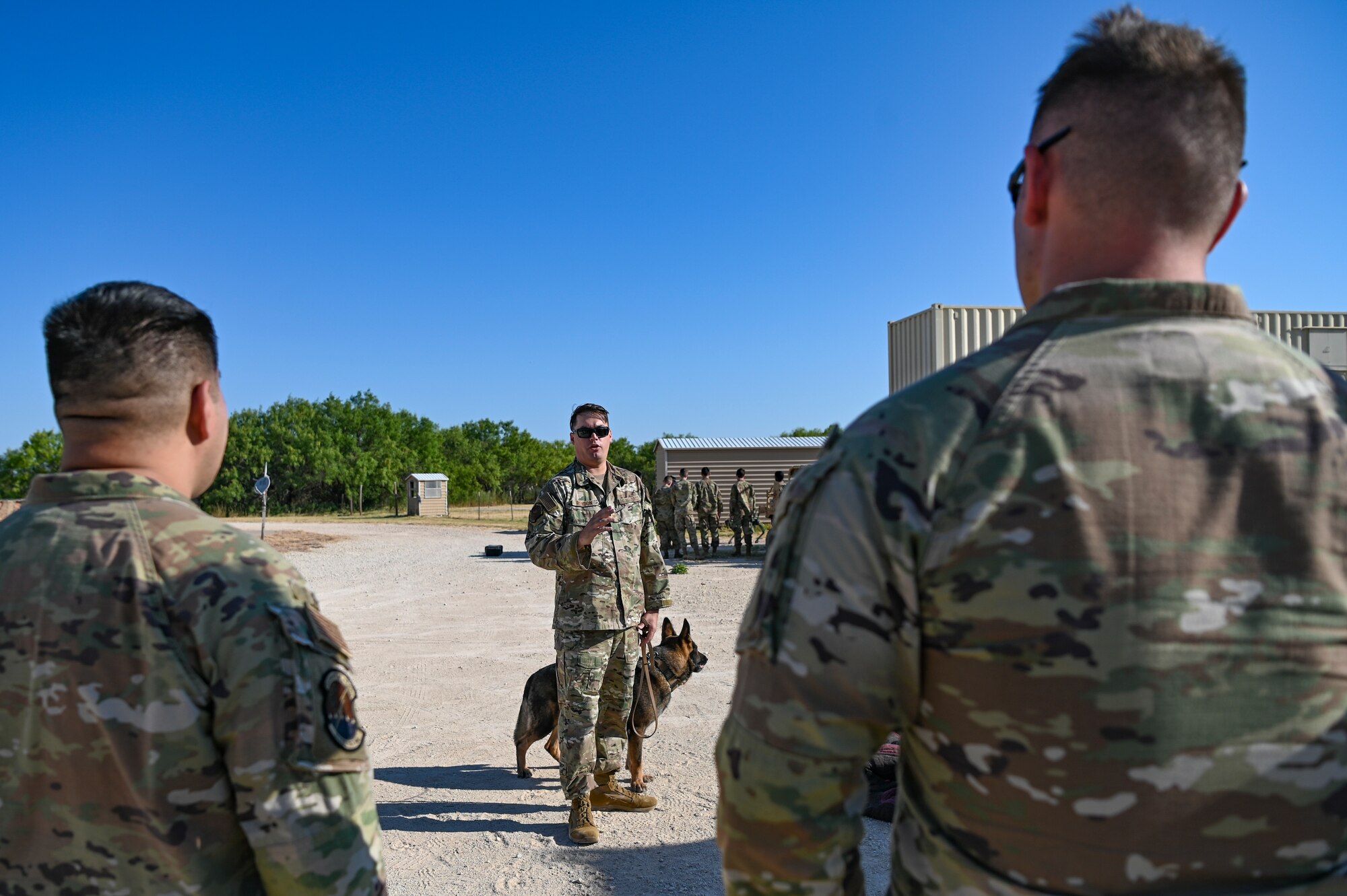 U.S. Air Force Staff Sgt. Eric Rendon, 7th Security Forces Squadron military working dog trainer, discusses military working dog capabilities with Air Force ROTC cadets during Project Tuskegee 2.0 at Dyess Air Force Base, Texas, Aug. 2, 2023. The project is intended to increase the cadets' understanding of Air Force and Space Force missions and day-to-day operations. The 19 cadets in attendance represent 19 different Air Force ROTC detachments across the enterprise's four regions. (U.S. Air Force photo by Airman 1st Class Emma Anderson)