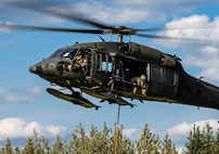 An Alaska Army National Guard UH-60L Black Hawk helicopter assigned to 207th Aviation Troop Command operates near Ladd Army Airfield Aug. 3., 2023 in support of wildland fire suppression across Interior Alaska. During fire suppression operations, the UH-60 employs a Bambi Bucket filled with approximately 630 gallons of water from a nearby lake. The Alaska Army National Guard deployed the UH-60 and air crew July 31, 2023 after receiving a resource request from the Alaska Division of Forestry and Fire Protection routed through the State Emergency Operations Center.