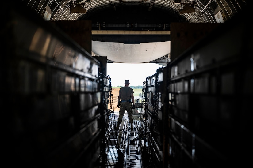 يقف أحد أفراد الخدمة داخل طائرة شحن عسكرية أثناء تحميل الأسلحة.