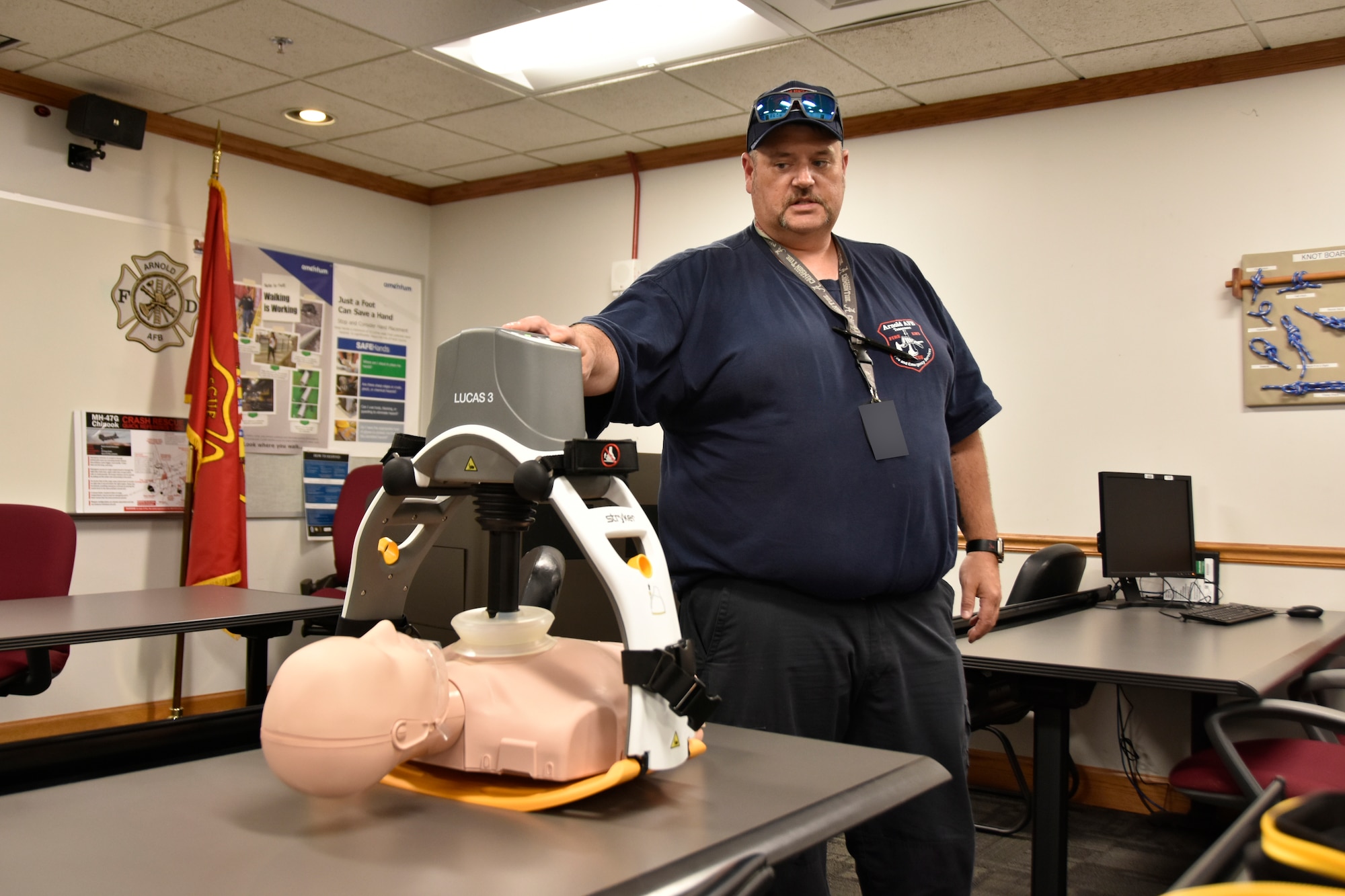 Stephen McCluskey, a firefighter and paramedic with Arnold Air Force Base Fire and Emergency Services at Arnold AFB, Tenn., demonstrates the LUCAS 3 Chest Compression System July 17, 2023. Arnold FES was able to acquire two of the automated CPR devices through Arnold Engineering Development Complex Spark Tank funding the department received earlier this year. Arnold AFB is the headquarters of AEDC. The LUCAS 3 is designed to deliver uninterrupted chest compressions at a consistent rate and depth, whether in the field, during transport and throughout arrival to the hospital. (U.S. Air Force photo by Bradley Hicks) (This image has been altered by obscuring a badge for security purposes.)