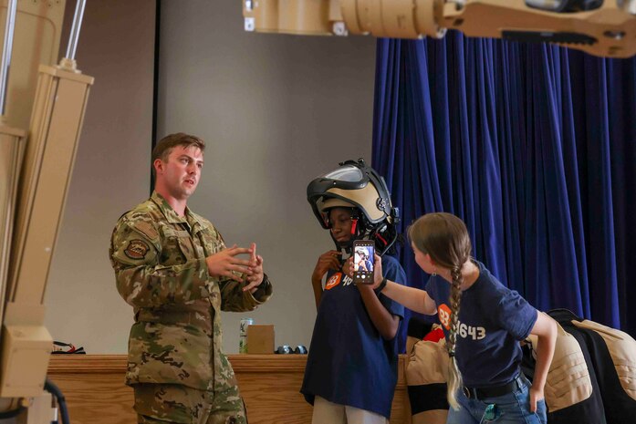 U.S. Air Force Staff Sgt. Connor Ely, 9th Civil Engineer Squadron explosive ordnance technician, shows Azalia Mutebi, a student with For Inspiration and Recognition of Science and Technology (FIRST), explosive ordnance disposal Personal Protective Gear during a base tour Aug. 3, 2023, at Beale Air Force Base, California.