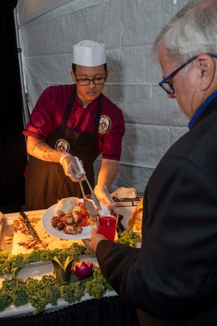 230805-N-YF131-1345 SEATTLE (Aug. 5, 2023) Culinary Specialist 3rd Class Randall Ramis, from Hialeah, Fla., assigned to the Arleigh burke-class guided-missile destroyer USS Barry (DDG 52), serves food at the Seattle Fleet Week closing reception. Seattle Fleet Week is a time-honored celebration of the sea services and provides an opportunity for the citizens of Washington to meet Sailors, Marines and Coast Guardsmen, as well as witness firsthand the latest capabilities of today’s U.S. and Canadian maritime services. (U.S. Navy photo by Mass Communication Specialist 2nd Class Madison Cassidy)