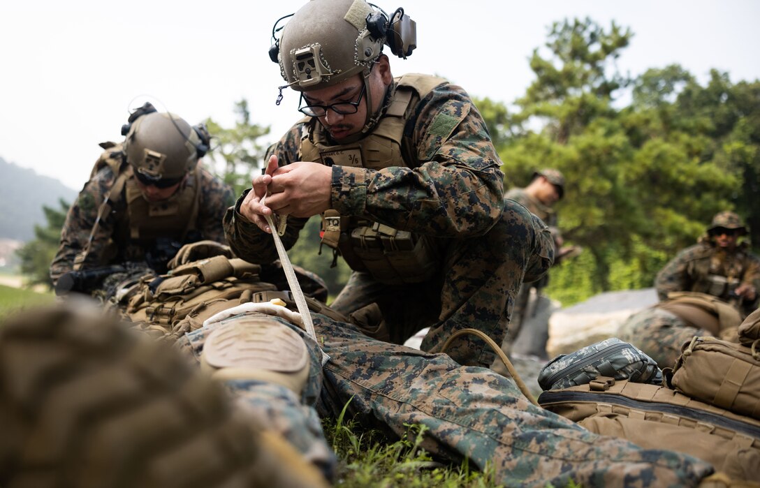 U.S. Navy Seaman Gerald Bryant wraps the wound of a simulated casualty as part of a medical evacuation training during Korea Marine Exercise Program 23.3 in the Republic of Korea, July 21, 2023. KMEP is conducted routinely to maintain the interoperability, proficiency, and combined capabilities of the ROK-U.S. forces. Alliance. Bryant, a native of Simpsonville, South Carolina, is a hospitalman with 3d Battalion, 5th Marines and is forward deployed in the Indo-Pacific under 4th Marine Regiment, 3d Marine Division as part of the Unit Deployment Program. (U.S. Marine Corps photo by Sgt. Jennifer Andrade)