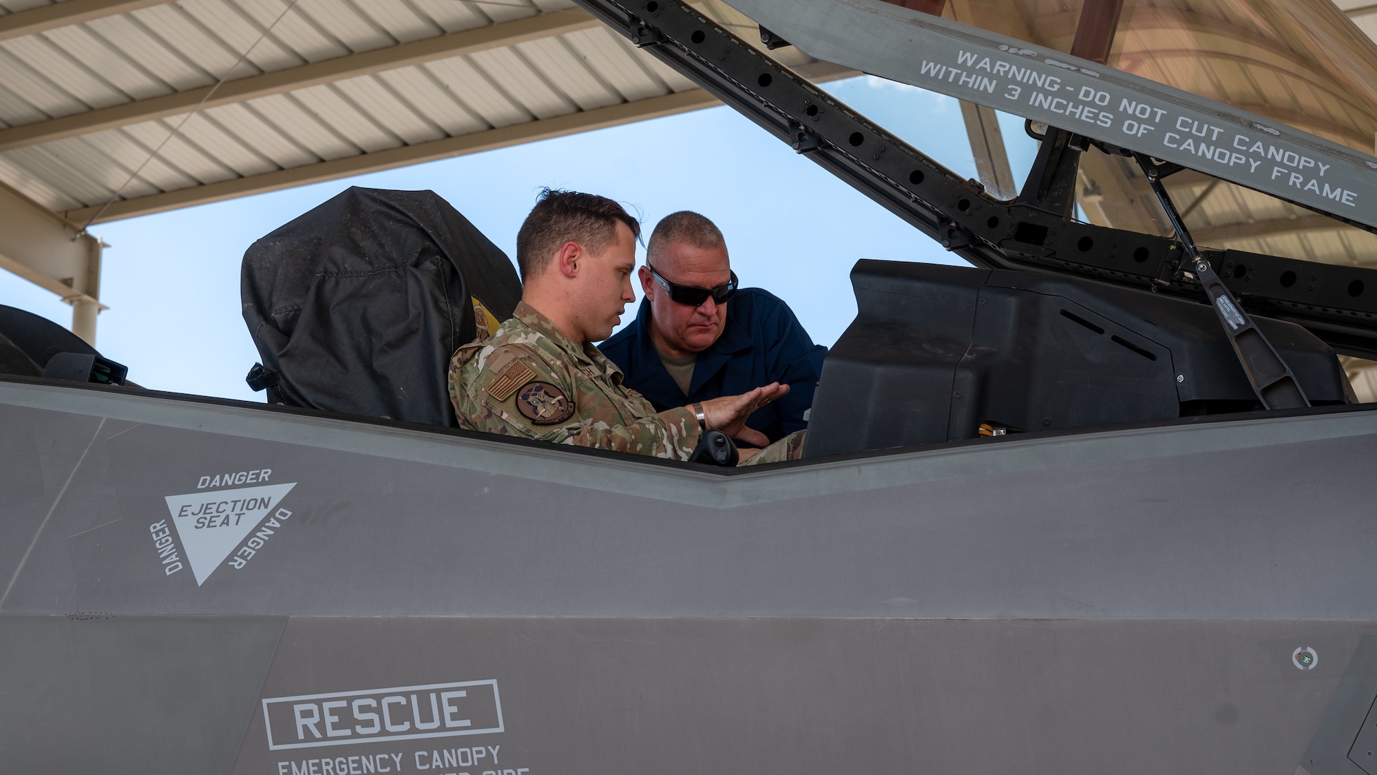 U.S. Air Force Chief Master Sgt. Justin Apticar, Nineteenth Air Force command chief, receives a brief on F-35A Lightning II capabilities by U.S. Air Force Tech. Sgt. Kyle Goodrich, 944th Fighter Wing F-35 crew chief, Aug. 1, 2023 at Luke Air Force Base, Arizona.